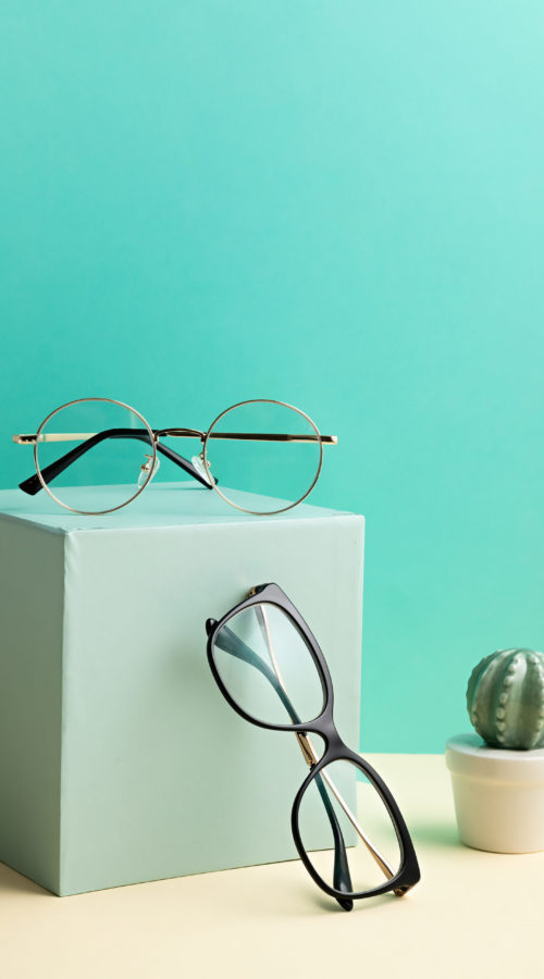 Stylish eyeglasses over pastel background. Optical store, glasses selection, eye test, vision examination at optician, fashion accessories concept Stylish eyeglasses over pastel background. Optical store, glasses selection, eye test, vision examination at optician, fashion accessories concept. Front view