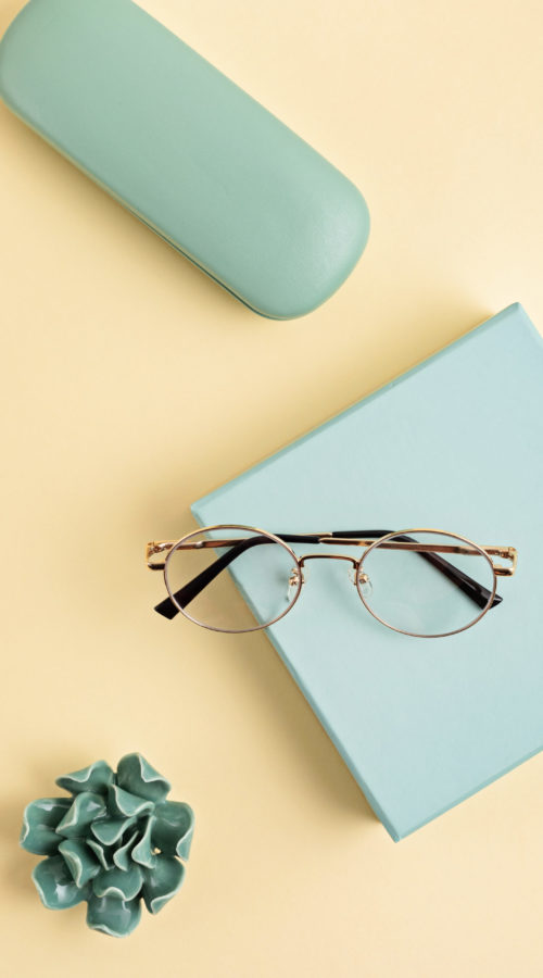 Stylish eyeglasses over pastel background. Optical store, glasses selection, eye test, vision examination at optician, fashion accessories concept. Top view Stylish eyeglasses over pastel background. Optical store, glasses selection, eye test, vision examination at optician, fashion accessories concept. Top view, flat lay